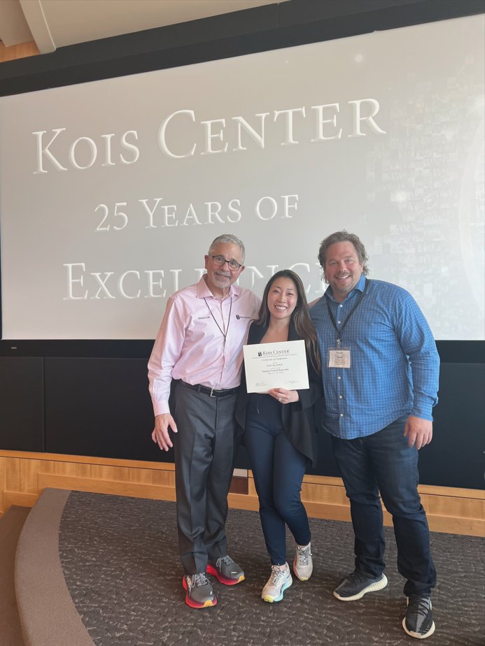 Dr. Erin Cho on stage at the Kois Center's 25 Years of Excellence event, holding her certificate