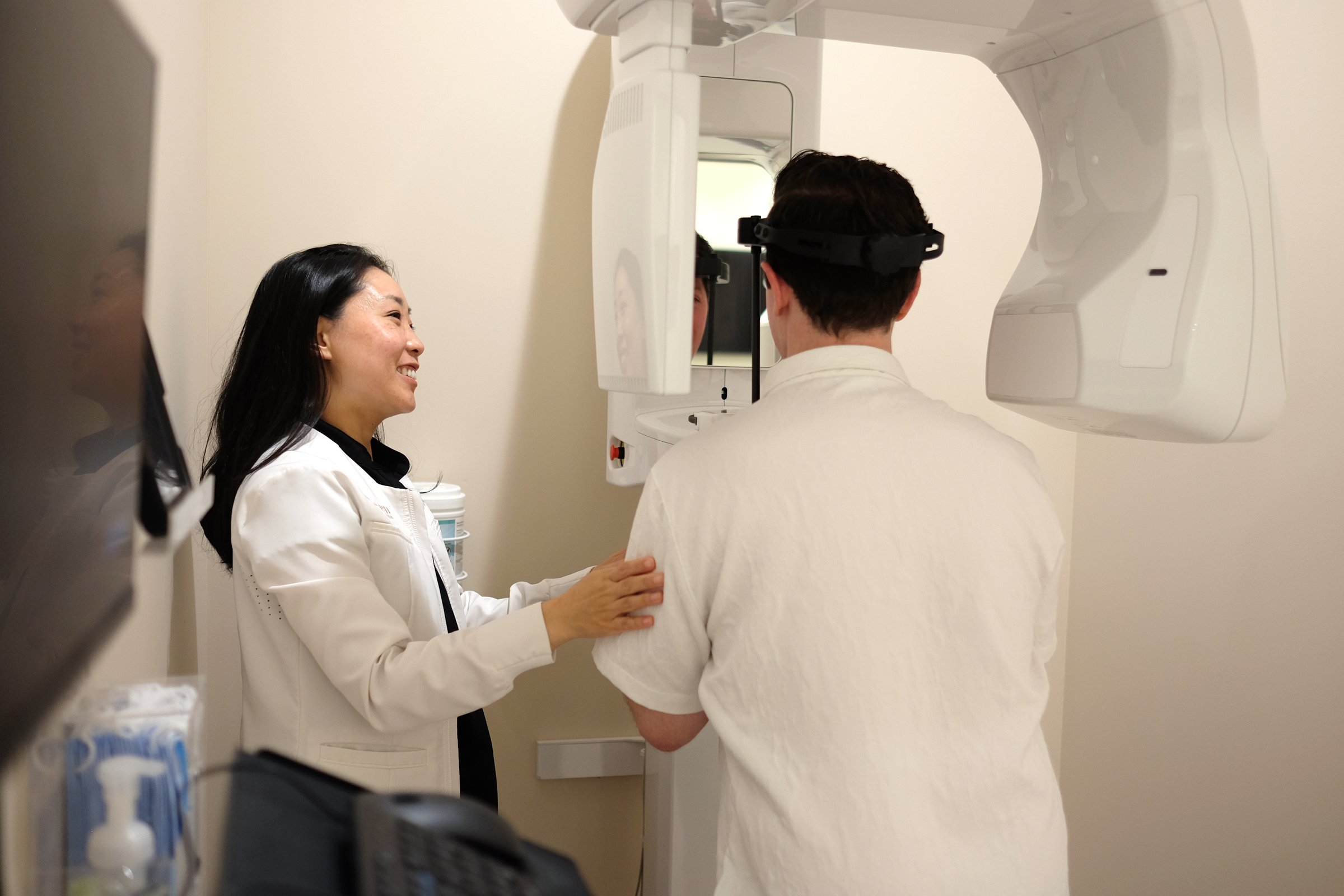 A Re·gen dentist guiding a patient into the 3D imaging machine