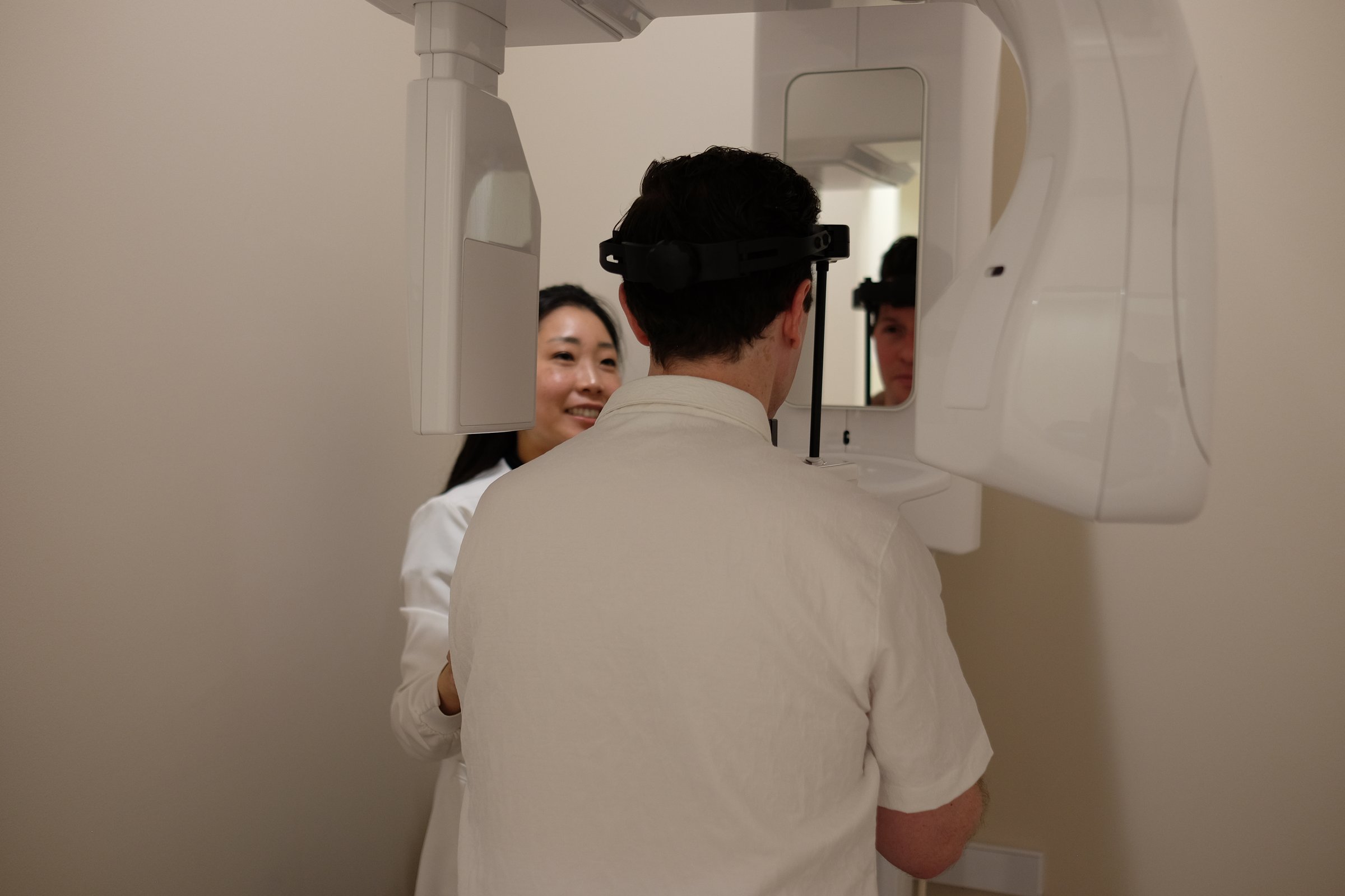 Dr. Erin Cho positioning a patient at the panoramic X-ray unit