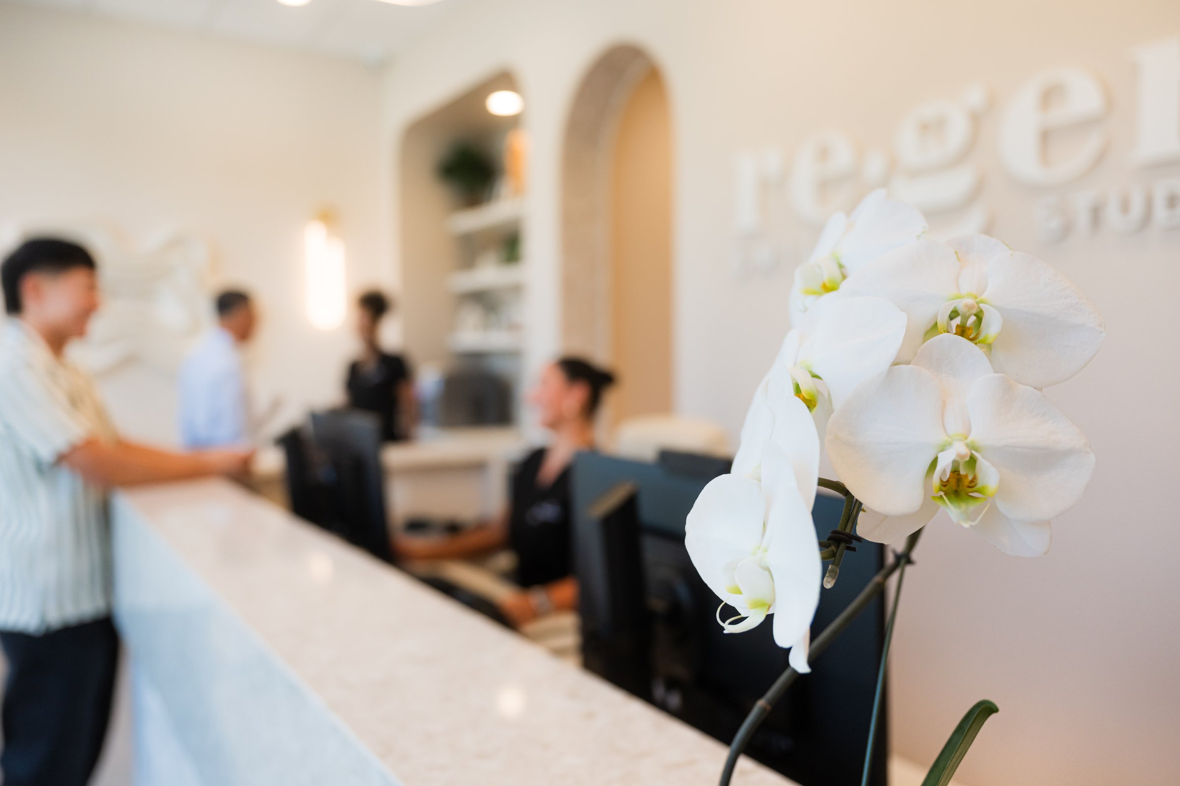 The front desk at Re·gen Smile Studio, orchids in the foreground