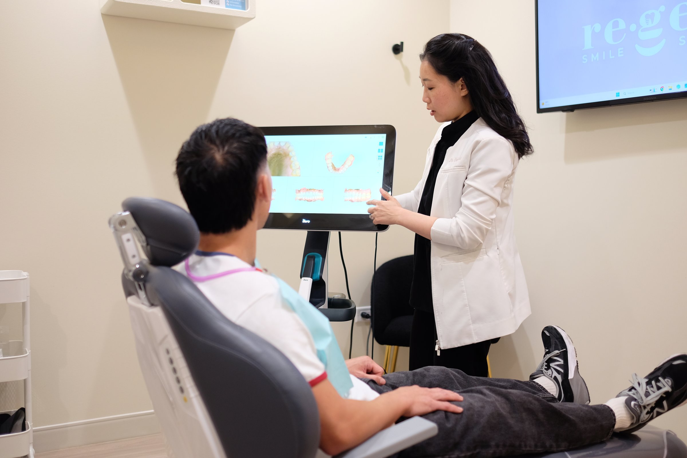 Dr. Erin Cho explaining a patient's scan to him in the treatment chair