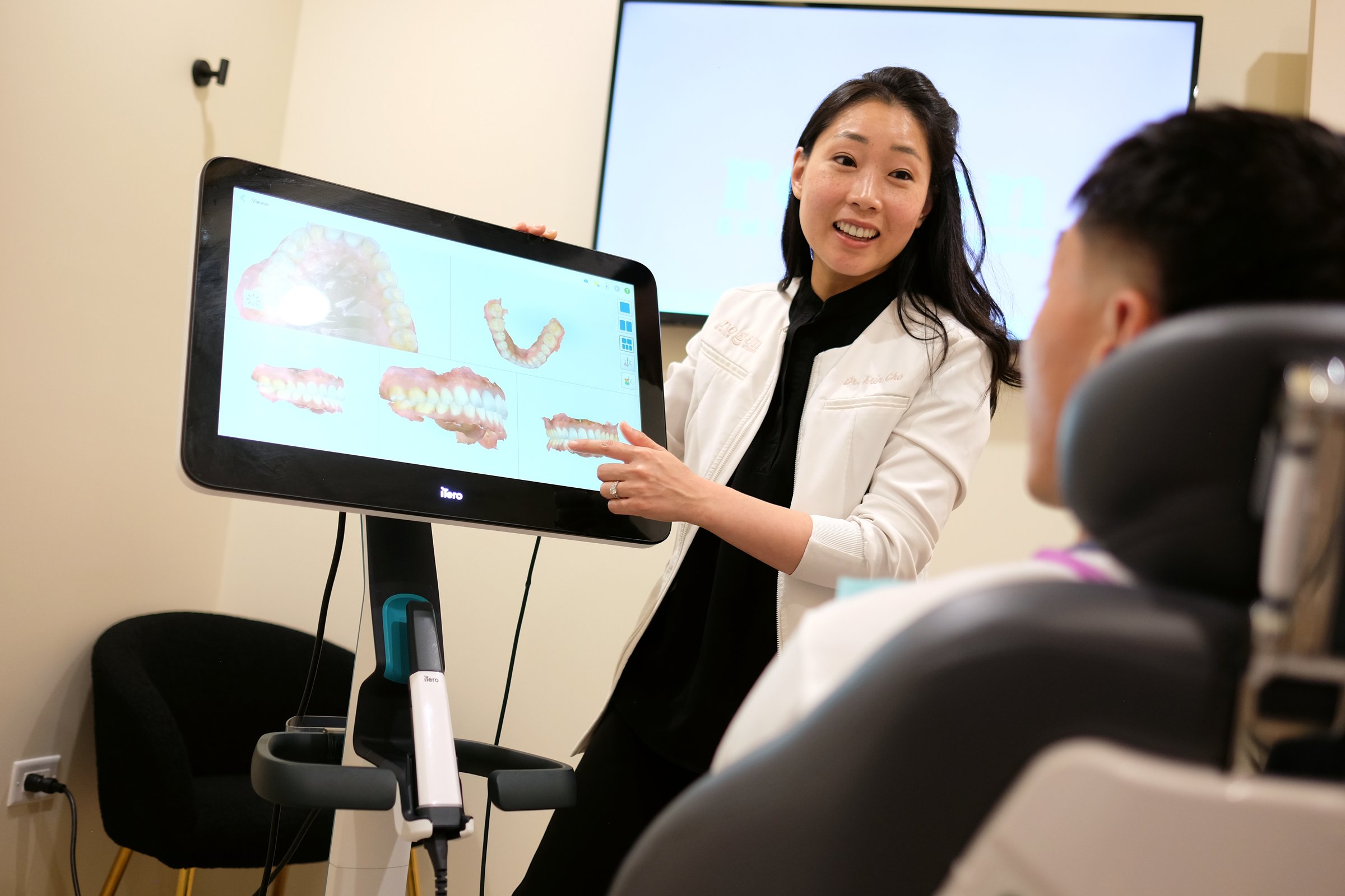 Dr. Erin Cho showing a patient his scan on a large screen