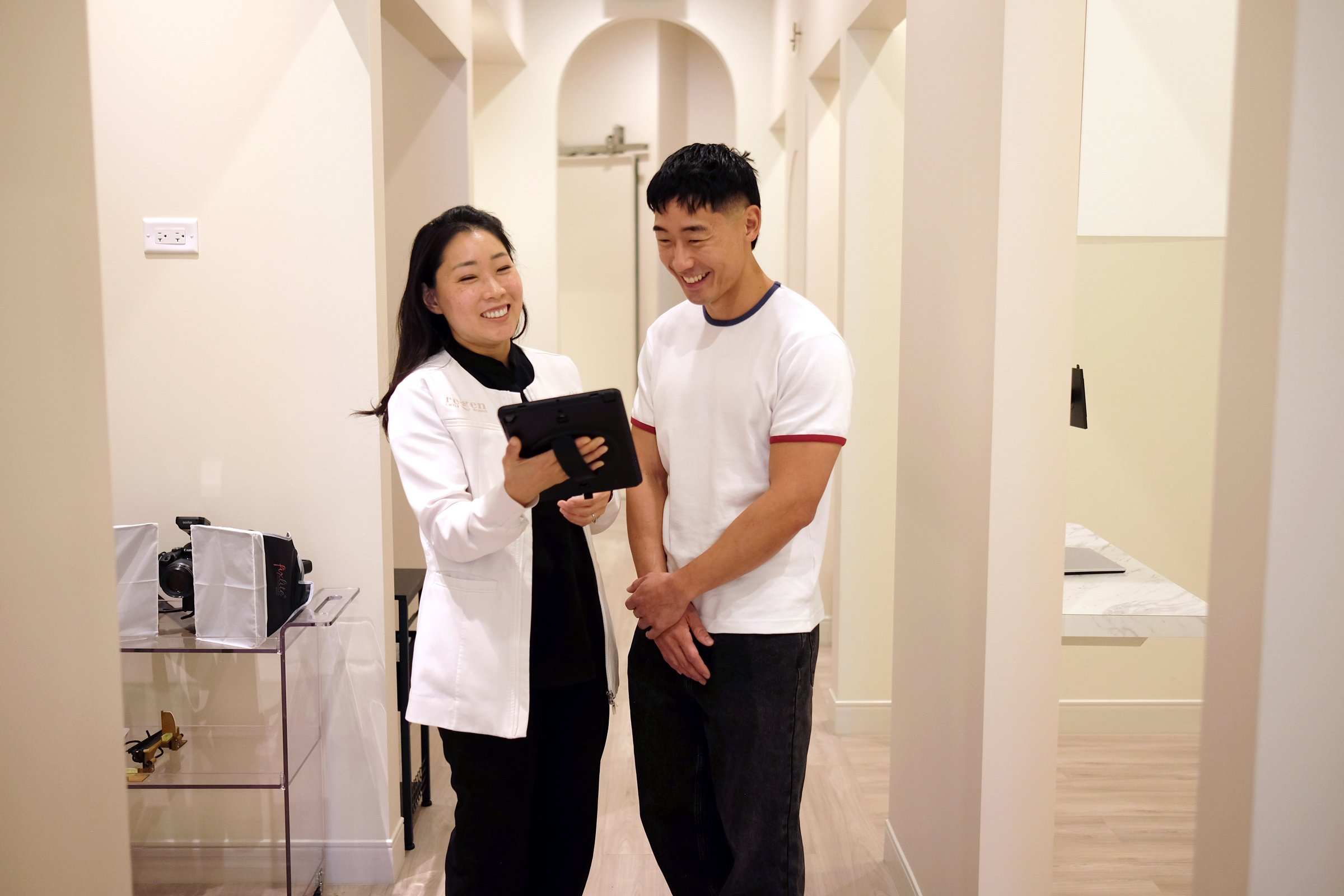 Dr. Erin Cho going over a plan on a tablet with a patient in the hallway