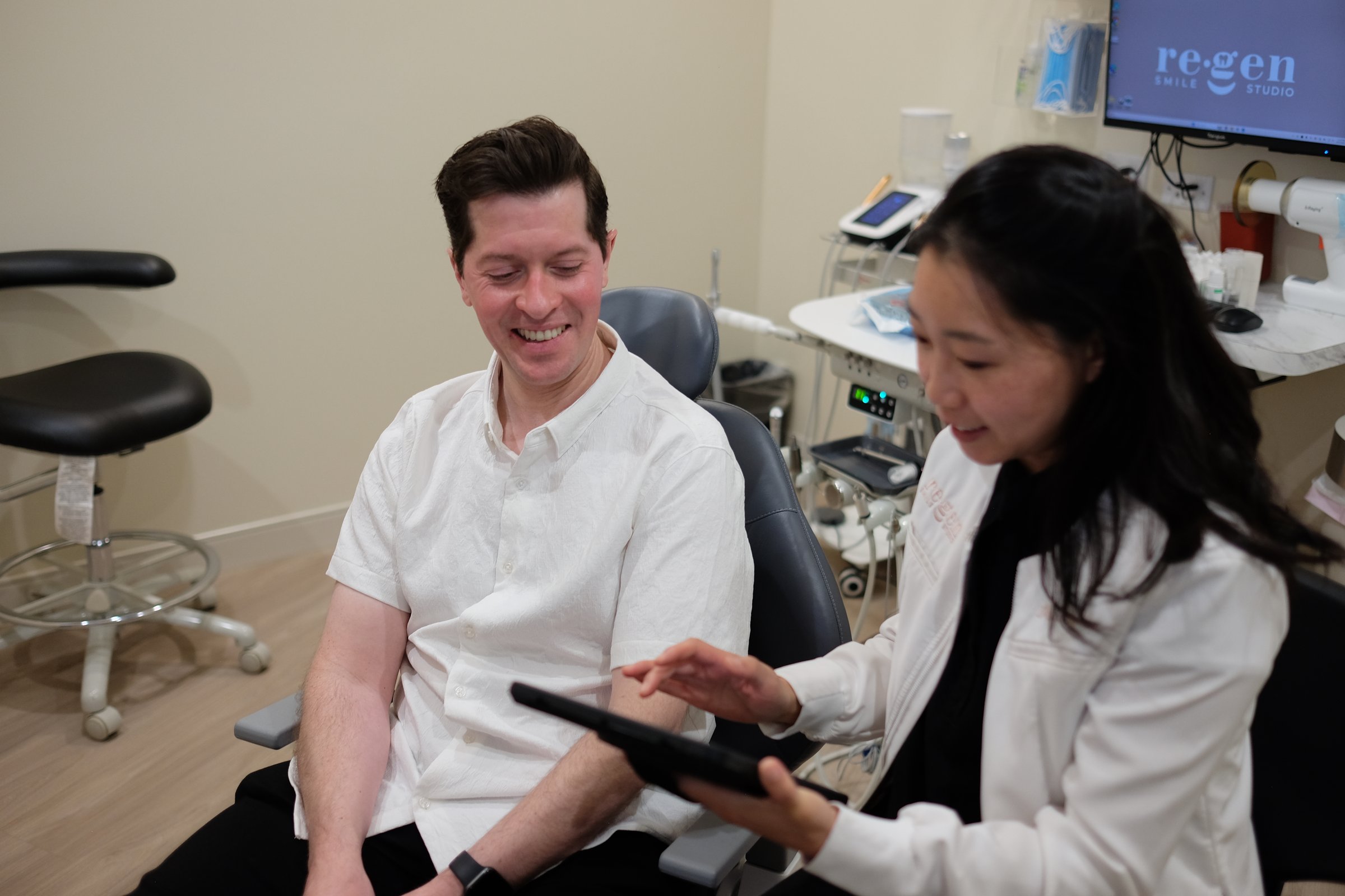 Dr. Erin Cho and a patient laughing over the plan on a tablet