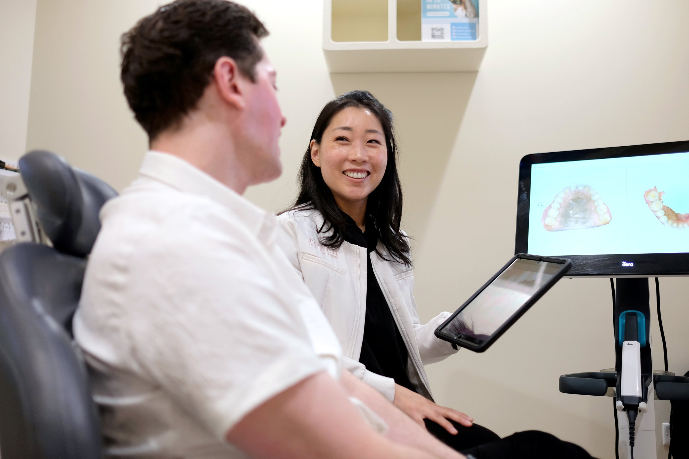 Dr. Erin Cho talking with a patient in the chair, his scan on the screen