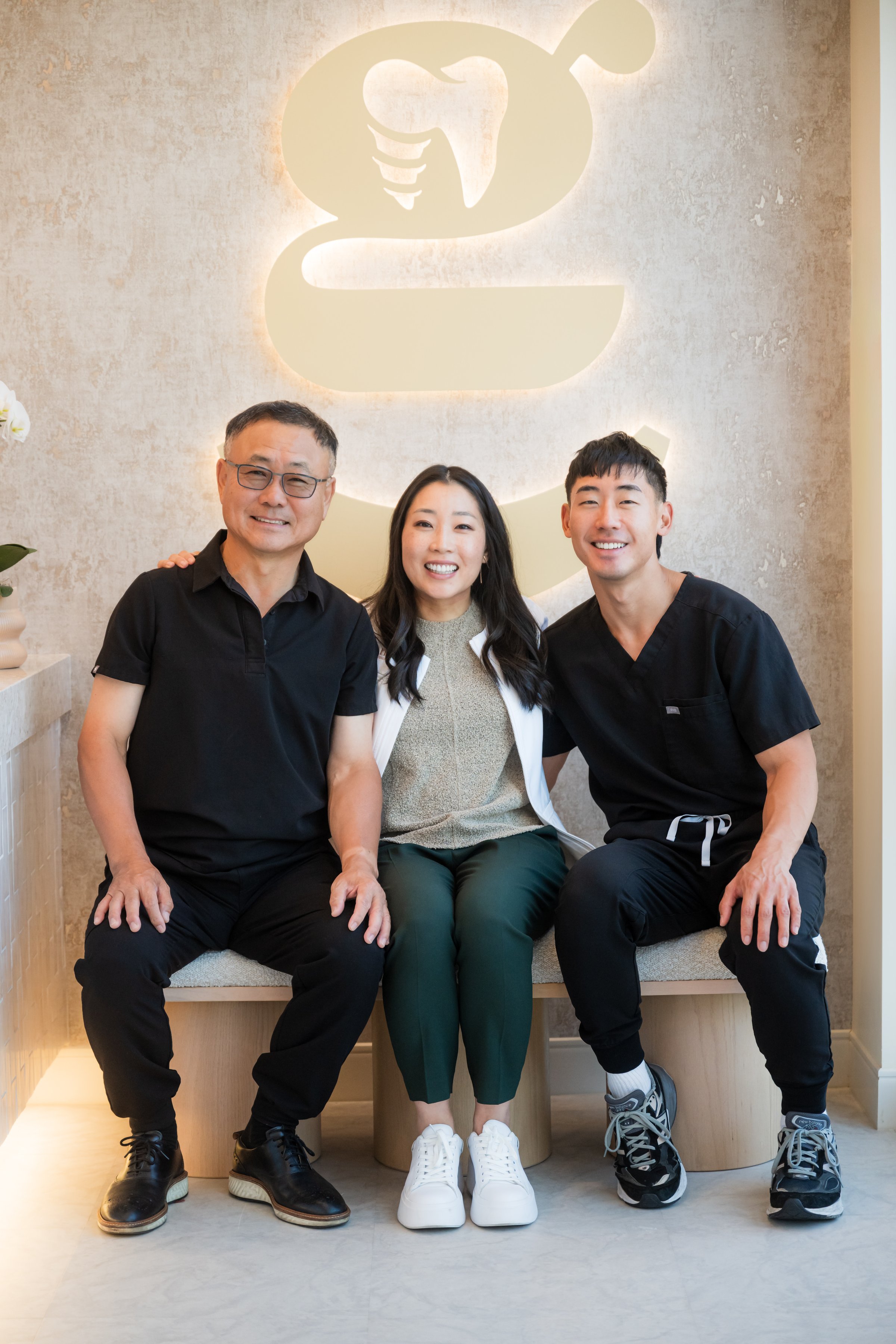 Dr. Erin Cho with her father and brother under the gold Re·gen mark in the studio