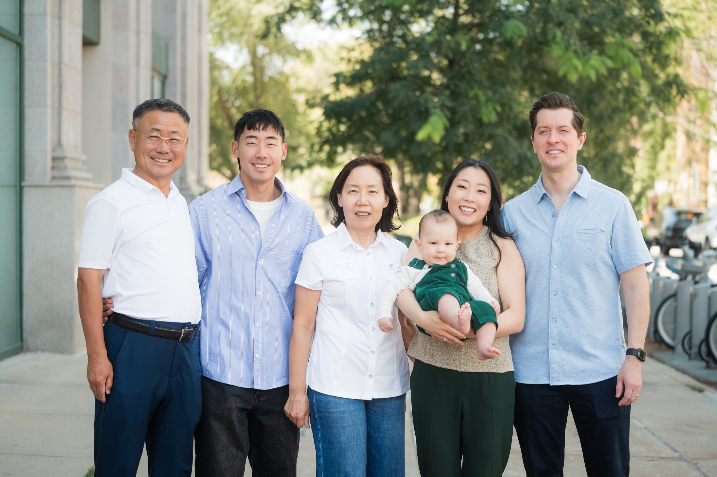 Dr. Erin Cho holding her baby, with her family on Lincoln Avenue