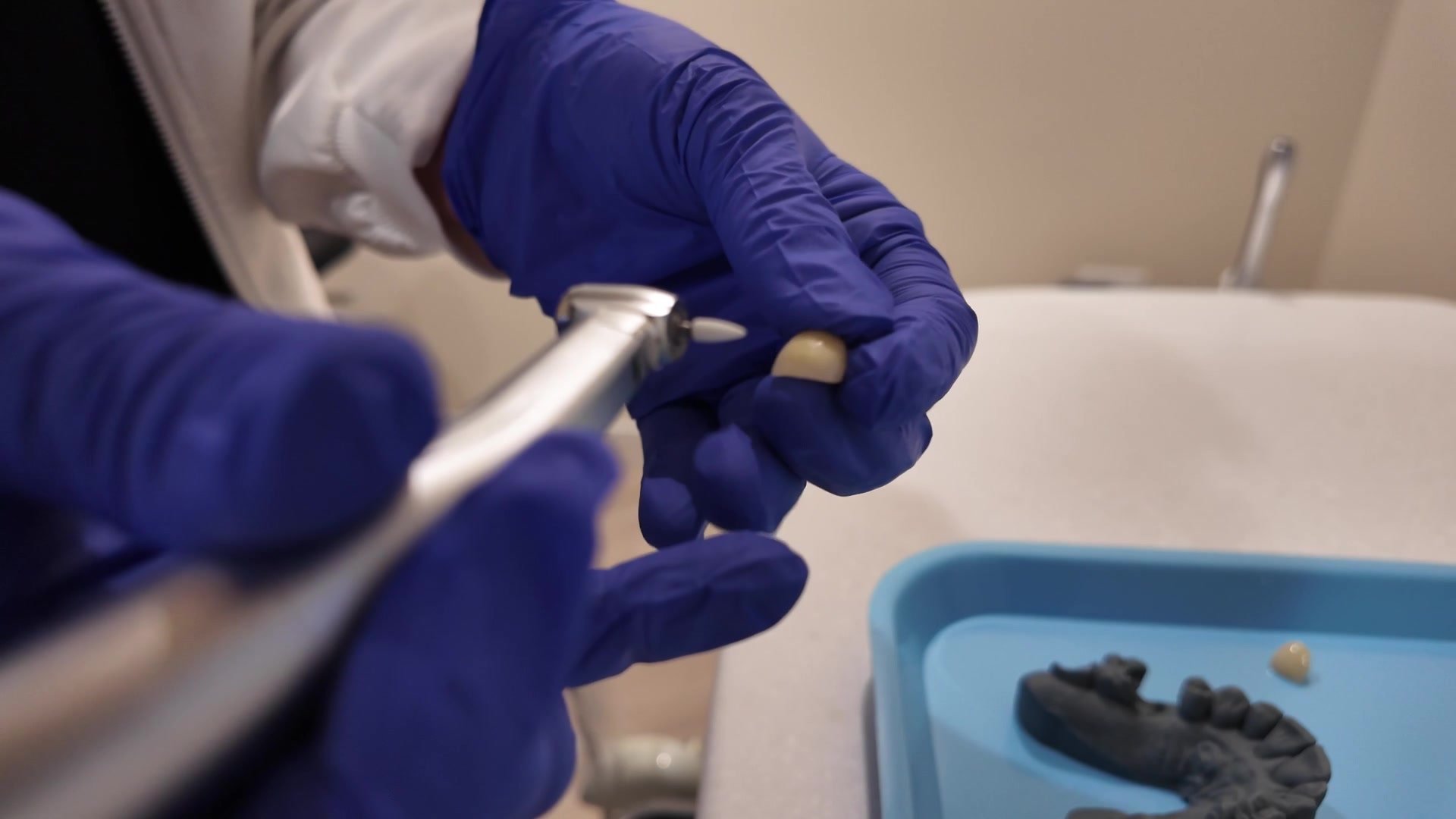 Gloved hands finishing a crown